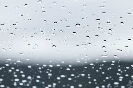 Closeup of car window with rain drops and mirrorの写真素材