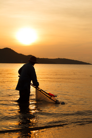 silhouette of fisherman working at lake when sunrise-2の写真素材