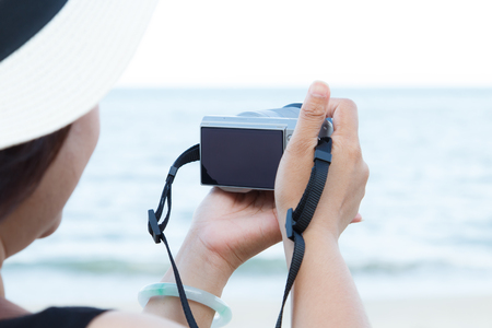 woman using the digital camera take phothos at seaの写真素材