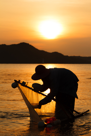 silhouette of fisherman working at lake when sunrise-3の写真素材