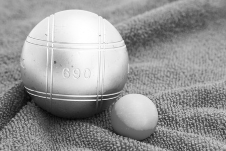 Metallic petanque ball and the small green jack on the blue backgroundの写真素材