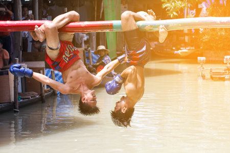 PATTAYA, THAILAND - JULY. 19 :traditional water Thai boxing (or Muay Talay) - ancient Thai fight above the water - at Pattaya floating market, Thailand on July 19, 2016.のeditorial素材