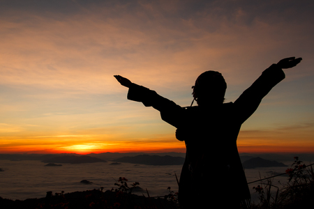 silhouette of woman gesturing success  over morning sky-2の写真素材