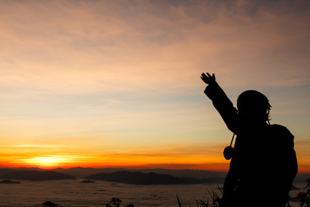 woman gesturing success - silhouette over morning skyの写真素材