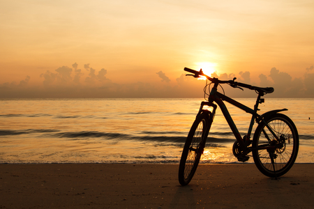 silhouette bicycle on the beach when sunsetの写真素材