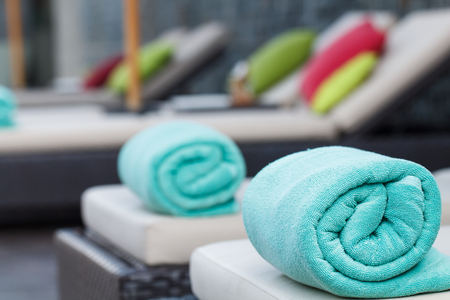 Green towel on beach chair in swimming poolの写真素材