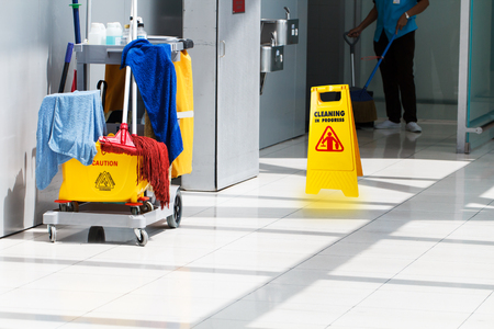 janitorial mop bucket on cleaning in process and worker backgroundの写真素材
