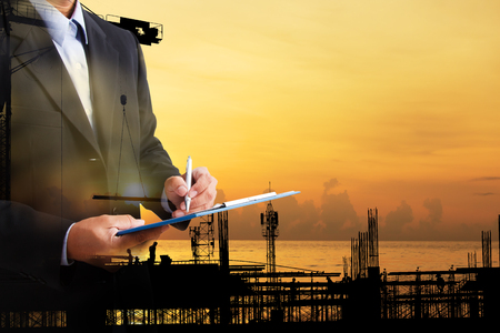 Silhouette construction engineer in the process of checking the construction site for the early morning jobs.の写真素材