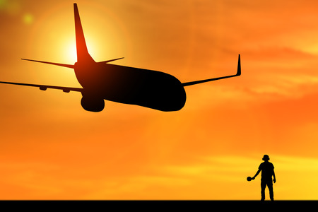 Silhouette of employee work for airplane departing flight at the airport with orange backgroundの写真素材