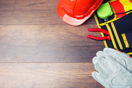 The yellow hard hat and construction tool on wooden board with copy space. Shows the concept of architects and buildersの写真素材