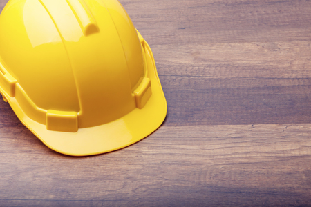 The yellow hard hat construction on wooden boardの写真素材