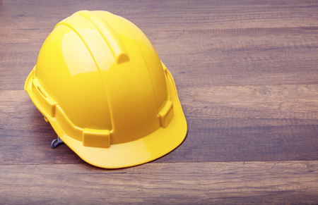 The yellow hard hat construction on wooden boardの写真素材