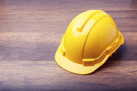 The yellow hard hat construction on wooden boardの写真素材