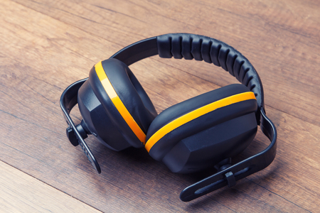 Ear protection placed on the wooden floor represents the concept of keeping the quality of hearing.の写真素材
