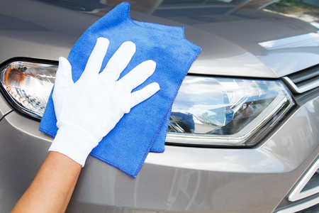 Hand of employees worker use clean blue cloth with white glove to wipe the car after washing in the car wash shopの写真素材