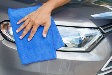 Hand of employees worker use clean blue cloth to wipe the car after washing in the car wash shopの写真素材