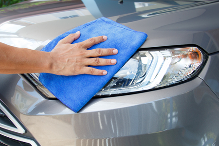 Hand of employees worker use clean blue cloth to wipe the car after washing in the car wash shopの写真素材