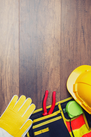 The yellow hard hat and construction tool on wooden board. Shows the concept of architects and buildersの写真素材