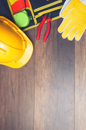 The yellow hard hat and construction tool on wooden board. Shows the concept of architects and buildersの写真素材