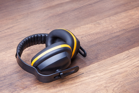 Ear protection placed on the wooden floor represents the concept of keeping the quality of hearingの写真素材
