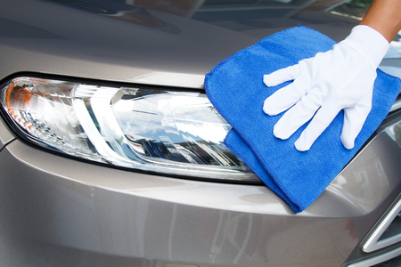 Hand of employees worker use clean blue cloth with white glove to wipe the car after washing in the car wash shopの写真素材