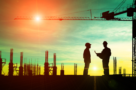 Silhouette of architect explaining the construction worker to the building plan for the correct understandingの写真素材