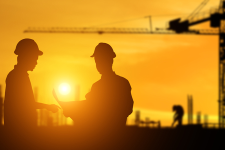 Silhouette of architect explaining the construction worker to the building plan for the correct understandingの写真素材