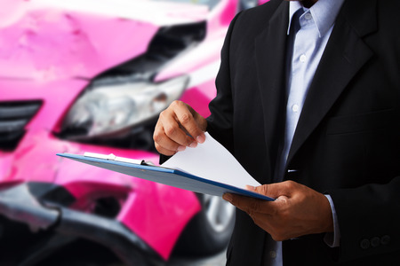 Car insurance agents open clipboard as a proof of insurance claim for taxi car accident damaged の写真素材