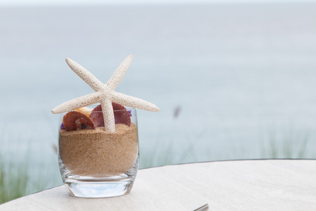 Shell on glass and sand with sea beach backgroundの写真素材
