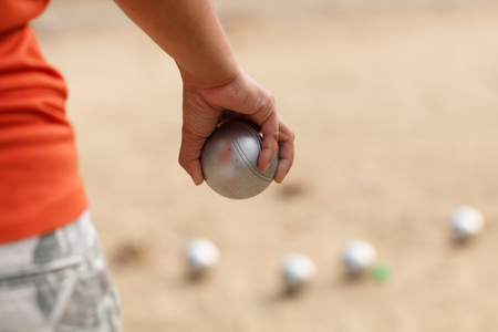 Hand of female boule holding boule or petanque ball on matchの写真素材