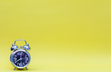 Minimalism of alarm clock on yellow background.の写真素材