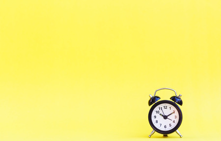 Minimalism of alarm clock on yellow background.の写真素材