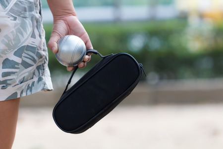 Hand of female boule holding boule or petanue ball and bag to prepare for a matchの写真素材