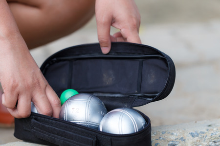 Hand of female boule pick up boule or petanque ball in bag to prepare for a matchの写真素材