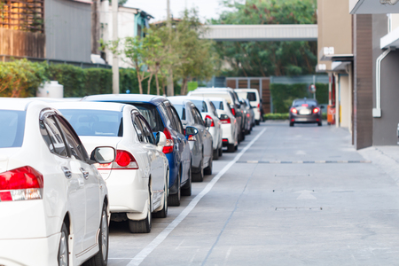 Car parked neatly inside an outdoor parking lot with blur car backgroundの写真素材