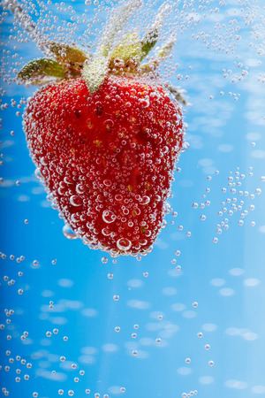 Fresh red strawberry in water splash with macro shotの写真素材