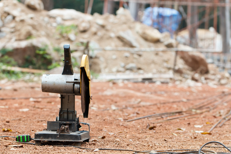 Electric steel cutting machine on the ground in sunny day with with construction site backgroundの写真素材