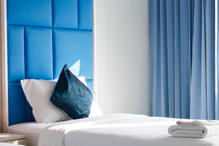 Blue color bed room interior with white towel and blue pillow on bedの写真素材