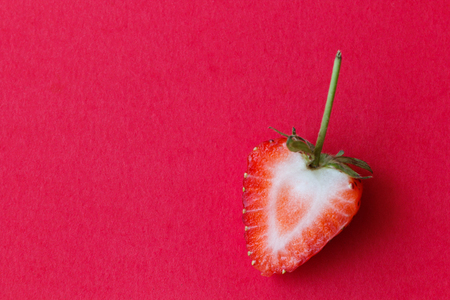 Half strawberry on red background with pastel colorの写真素材