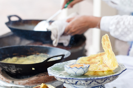 Thai crispy pancakes  on process with hand chef in backの写真素材