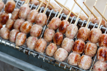 Thai street food, Sausage is grilled on a hot plate to prepare customersの写真素材