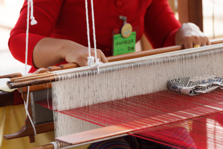 woman weaving silk cotton on the manual wood loom in Thailand, selective focus