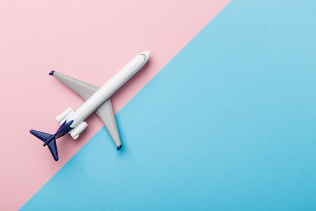 Miniature airplane travel theme on pink and blue backgroundの写真素材