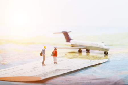 Concept of macro mand and woman people model travel with ticket and airplaneの写真素材