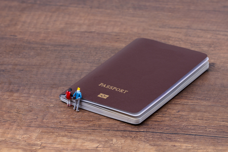 Couple miniature people with passport and airplane ticket, concept of travelの写真素材