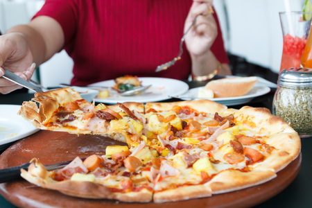 Woman hands taking slices of Pizza, selective focusの写真素材