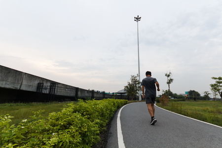 Runner athlete running at tropical park. man fitness jogging workout wellness concept.の写真素材