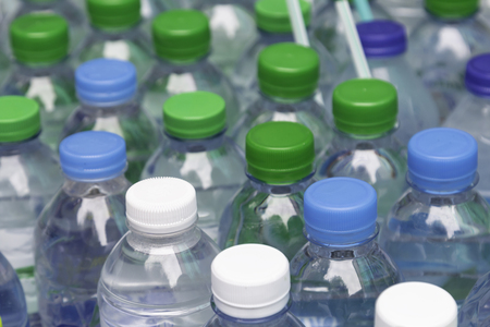 Many bottles of clean water with white blue and green lids and straws, concept of no plasticの写真素材