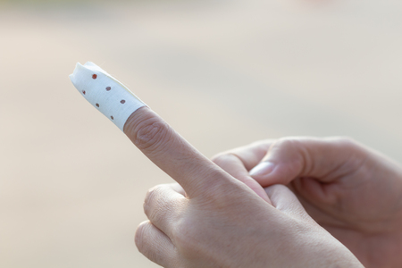 medicine bandage on woman injury hand finger.の写真素材