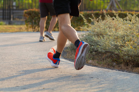 Sport background, close up of urban runner's legs run on the street of public park with copy space.